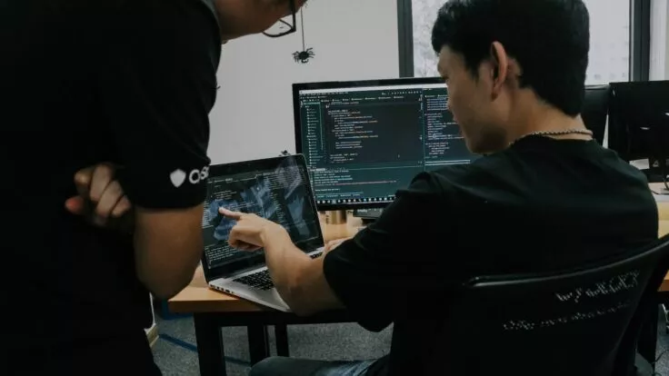 The person working on the computer shows his colleague